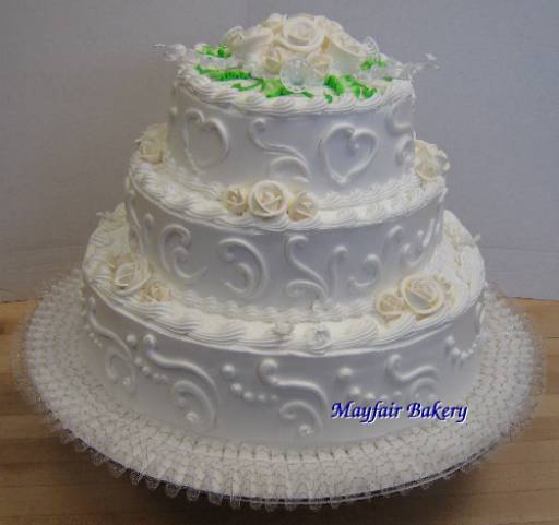 Three tier white wedding cake with scrollwork