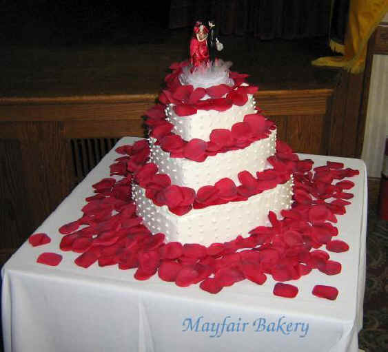 Three tier heart shape wedding cake with rose petals